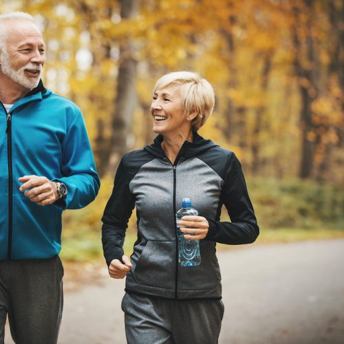 Senior couple jogging in a forest.