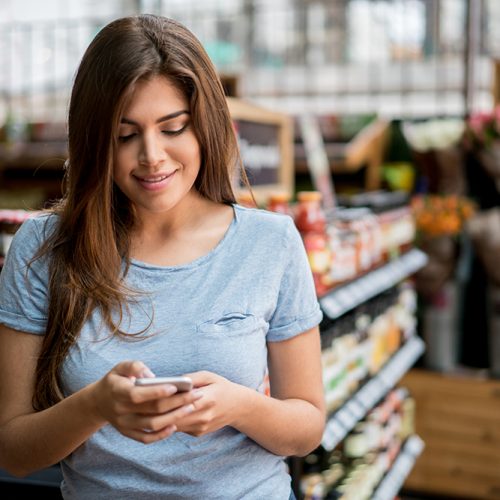 Woman at the supermarket going through a shopping list
